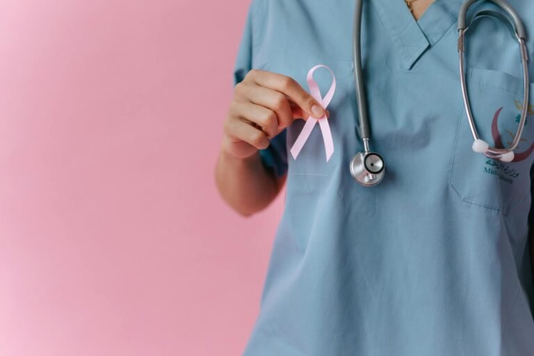 a medical professional holding a pink ribbon