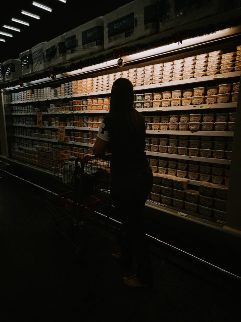 silhouette of woman shopping in grocery aisle