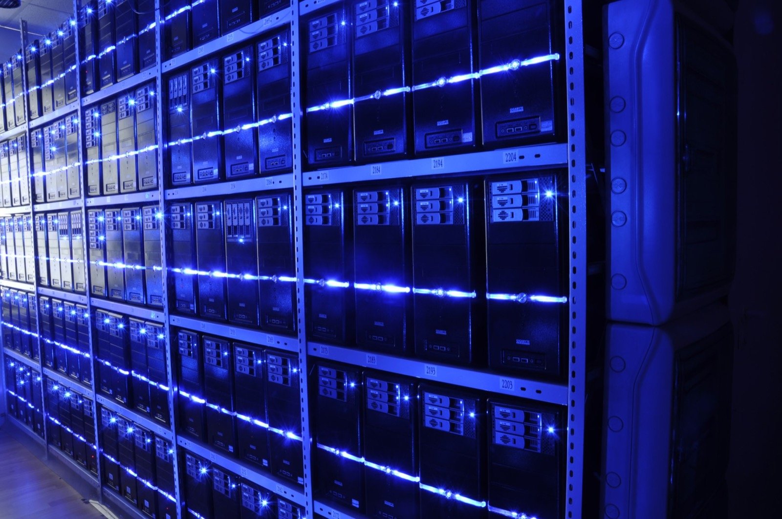 Filas de servidores iluminados dentro de un centro de datos