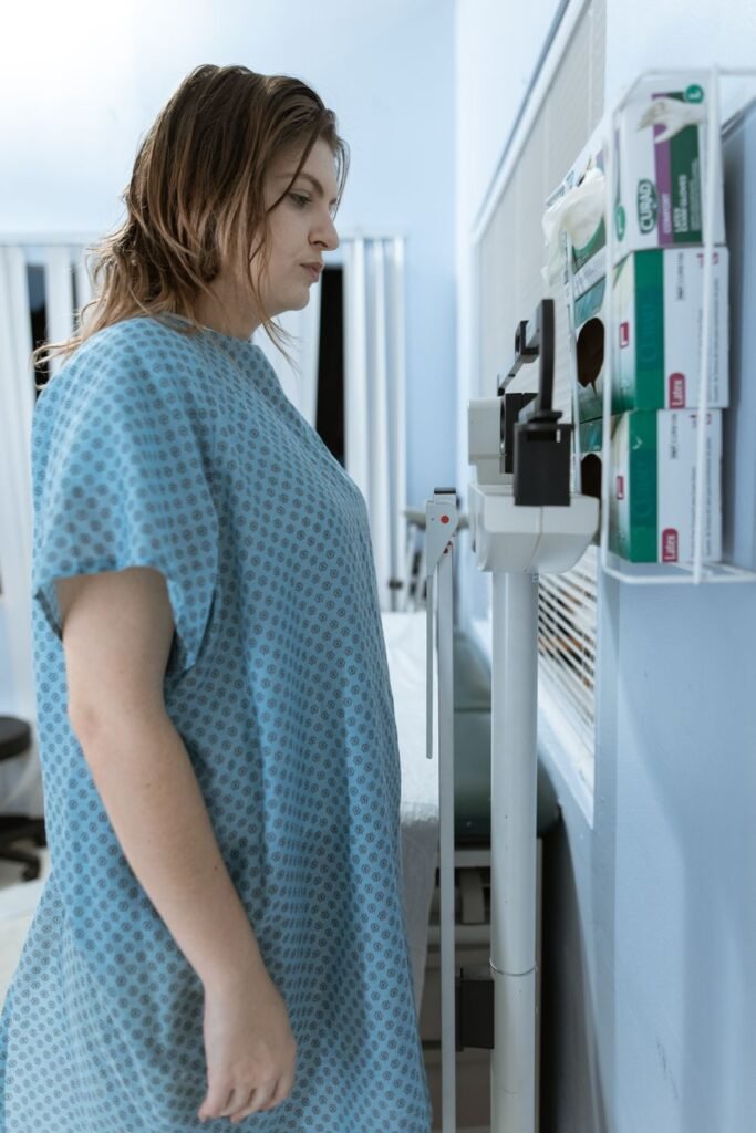 female patient standing in a weighing scale