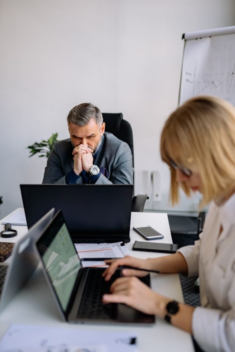 an exhausted businessman looking at his laptop
