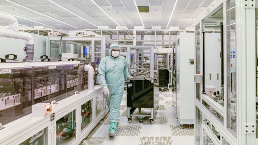 Especialista con equipo de protección dentro de una sala limpia tecnológica