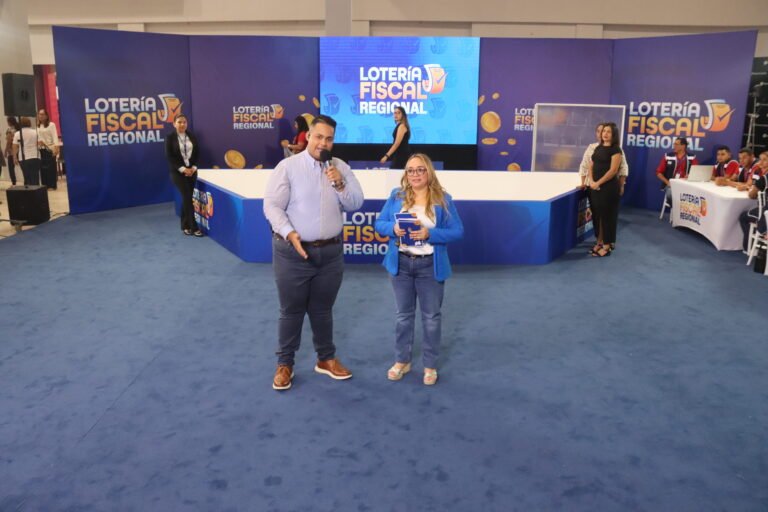 Presentadores frente al escenario de la Lotería Fiscal Regional