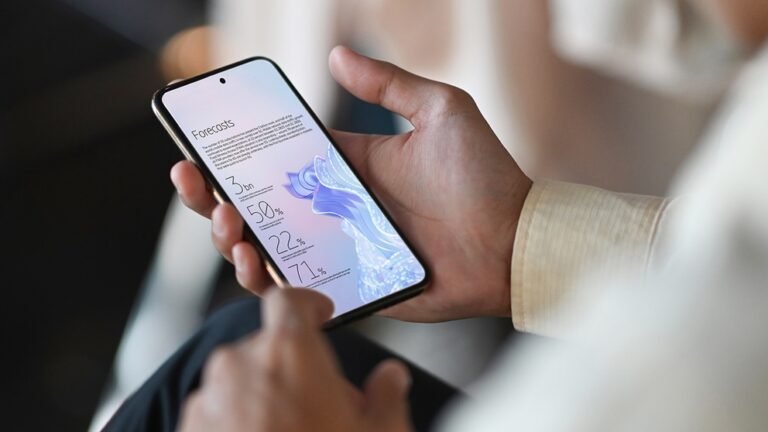 Una persona sostiene un teléfono con las previsiones del Ericsson Mobility Report 2026