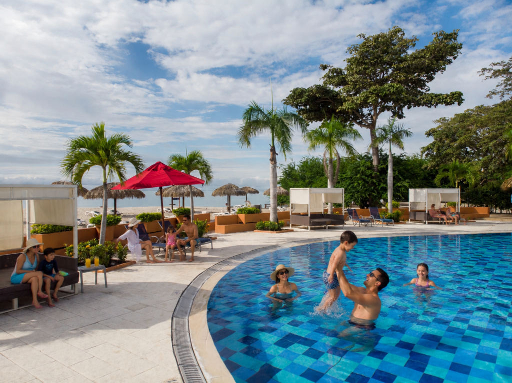 Familias disfrutan de una piscina frente a la playa en Grand Decameron Panamá