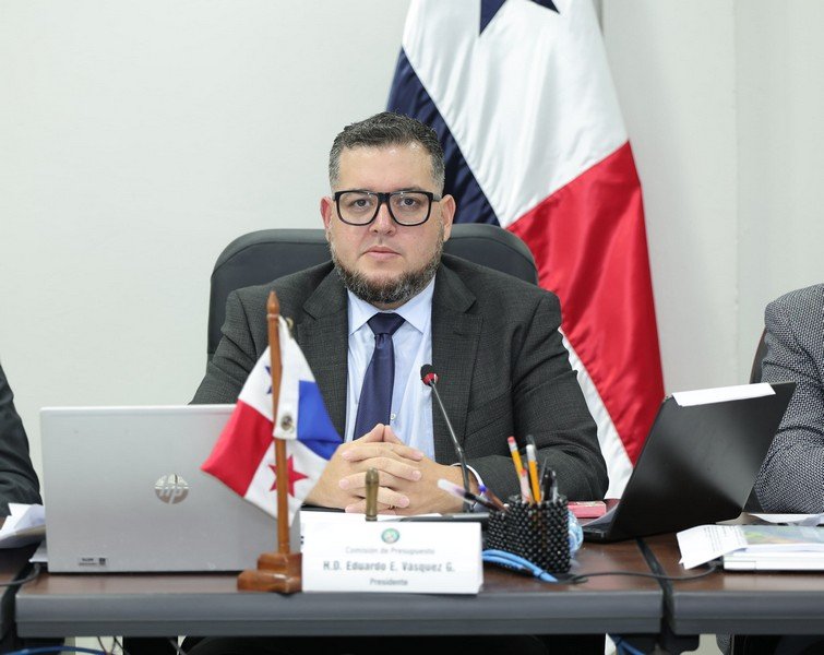Eduardo Vásquez sentado ante un micrófono y documentos en la Comisión de Presupuesto.