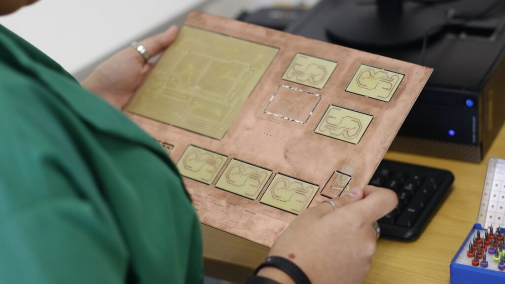 Una técnica inspecciona una placa utilizada en el desarrollo de componentes electrónicos