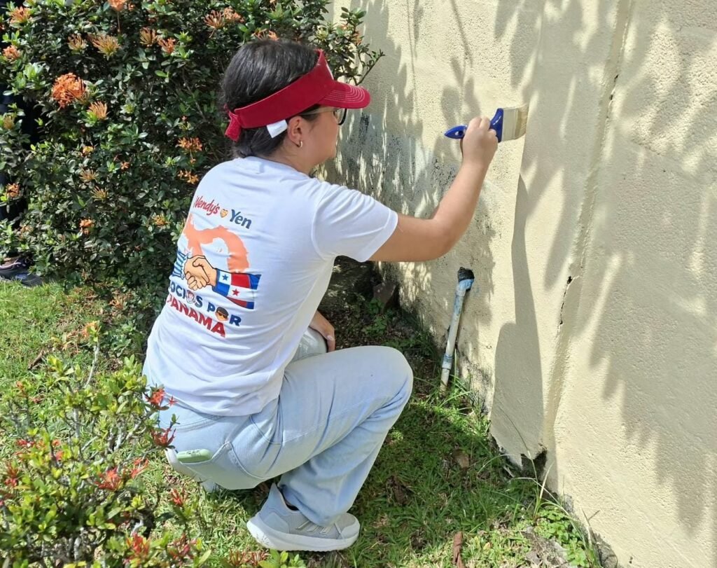 Colaboradora de Wendy’s Panamá pintando una pared durante una jornada de voluntariado