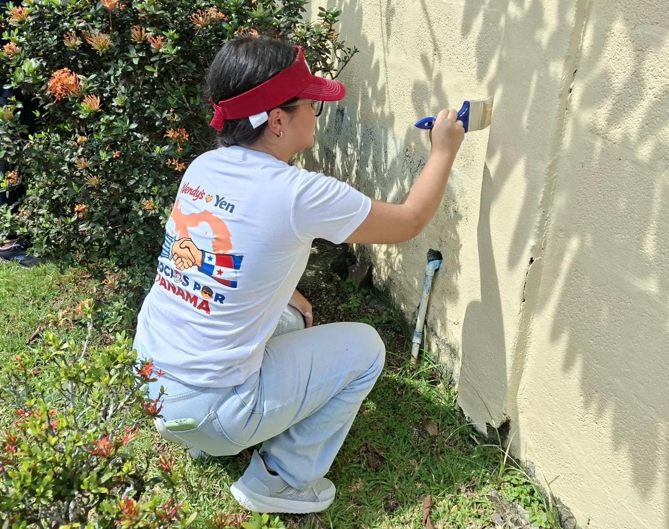 Colaboradora de Wendy’s Panamá pintando una pared durante una jornada de voluntariado