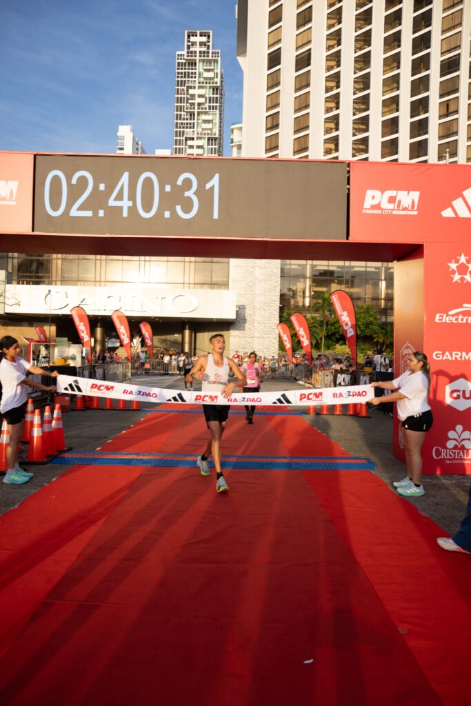 Un corredor cruza la cinta de llegada de la Panama City Marathon 2026.