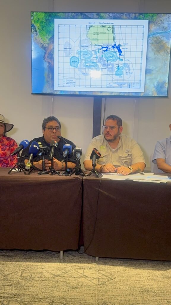 Participantes de la conferencia sobre el cierre de Cobre Panamá, junto a micrófonos y un mapa del proyecto