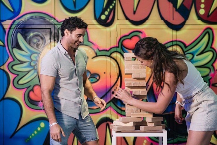 Dos personas participan en un juego de bloques de madera en un área recreativa de Grand Decameron Panamá.
