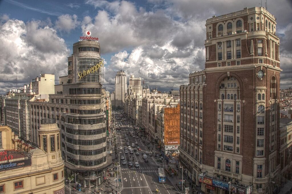 Vista de la Gran Vía de Madrid, con edificios, comercios y tráfico.