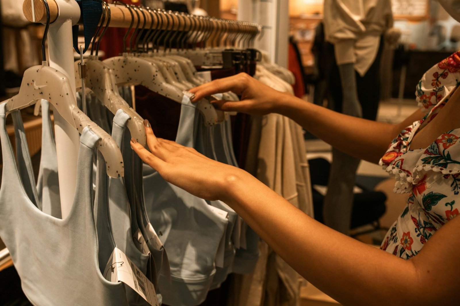 woman choosing tops on hangers