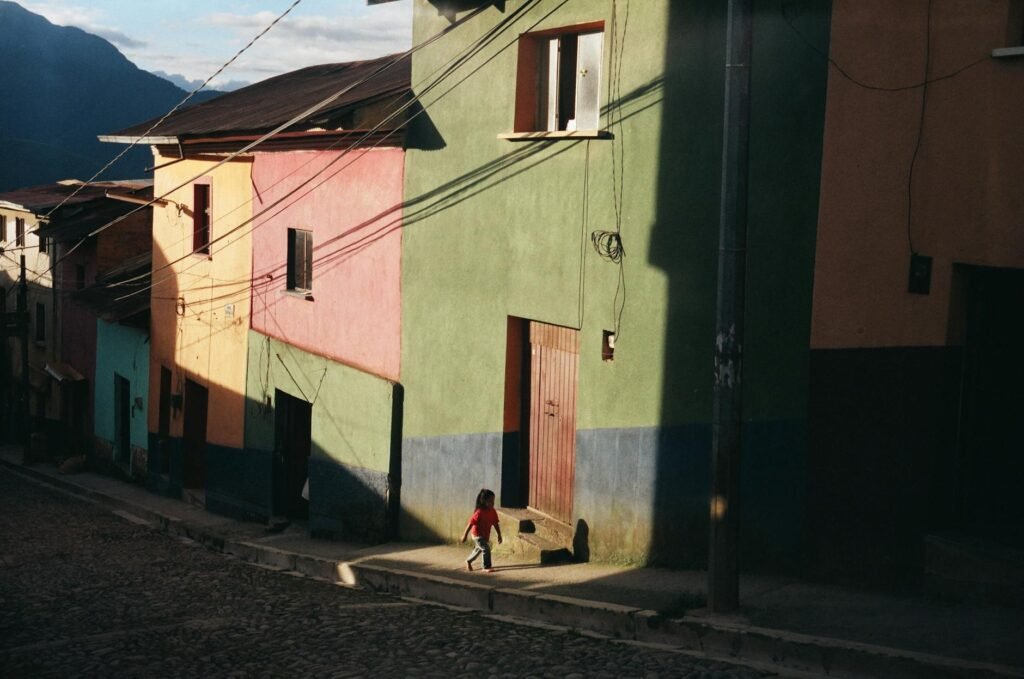 child walking on the sidewalk near colorful houses