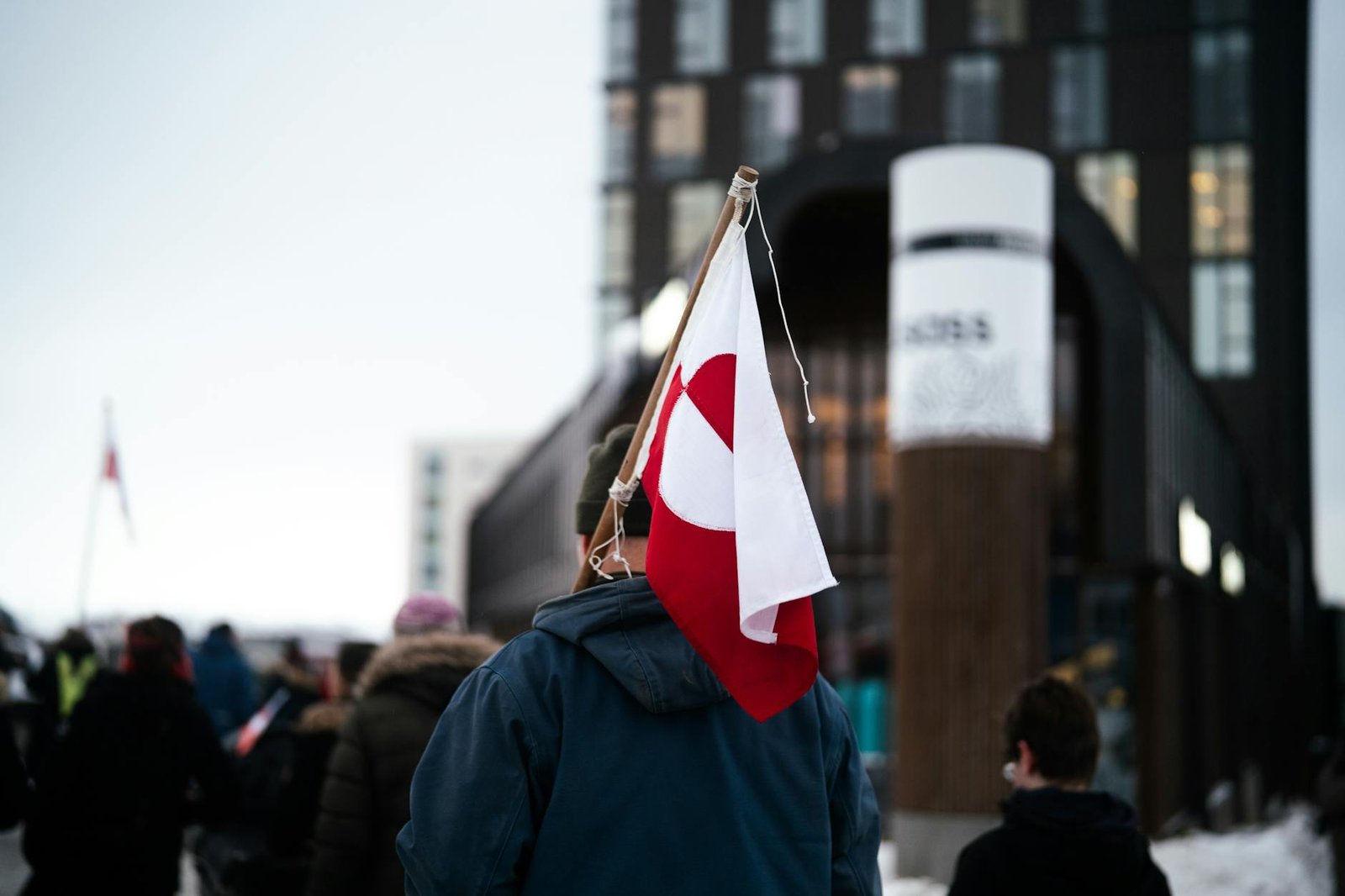 protestor with greenland flag in urban setting