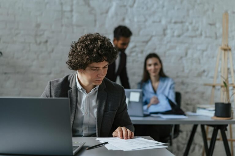 man in black suit looking the document