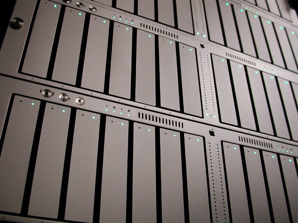 Primer plano de una matriz de almacenamiento de datos de servidor con múltiples bahías de discos duros y luces indicadoras LED verdes