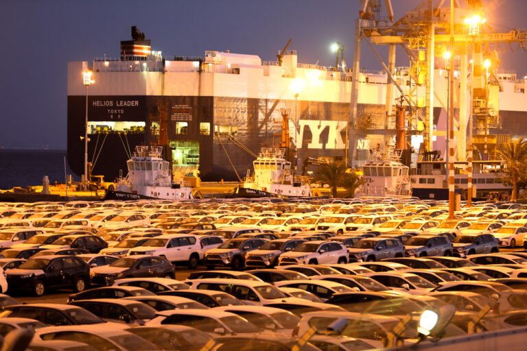 Buque japonés Helios Leader de NYK en una terminal portuaria con automóviles listos para transporte