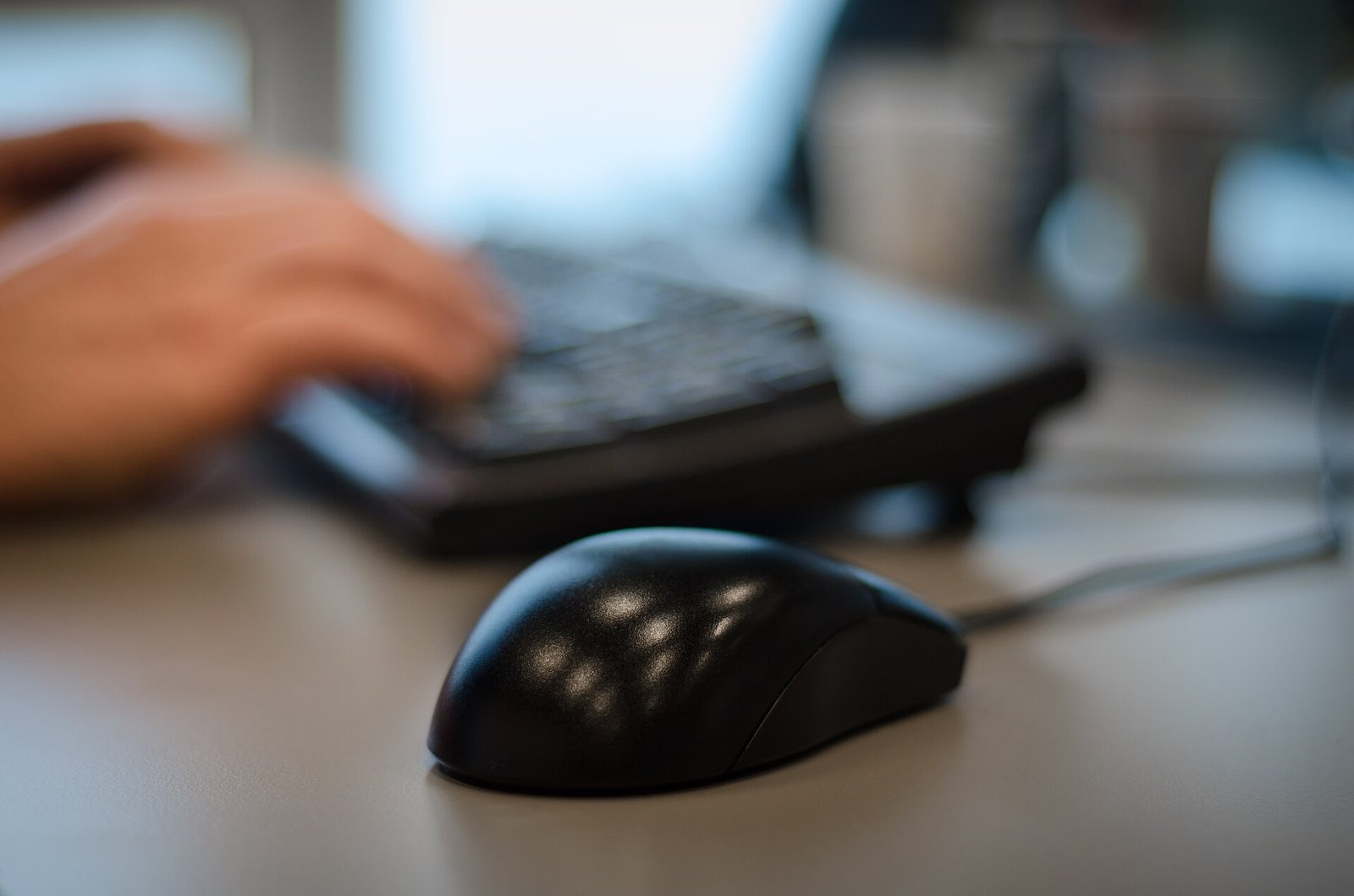 Persona trabaja con una computadora y un teléfono en un escritorio