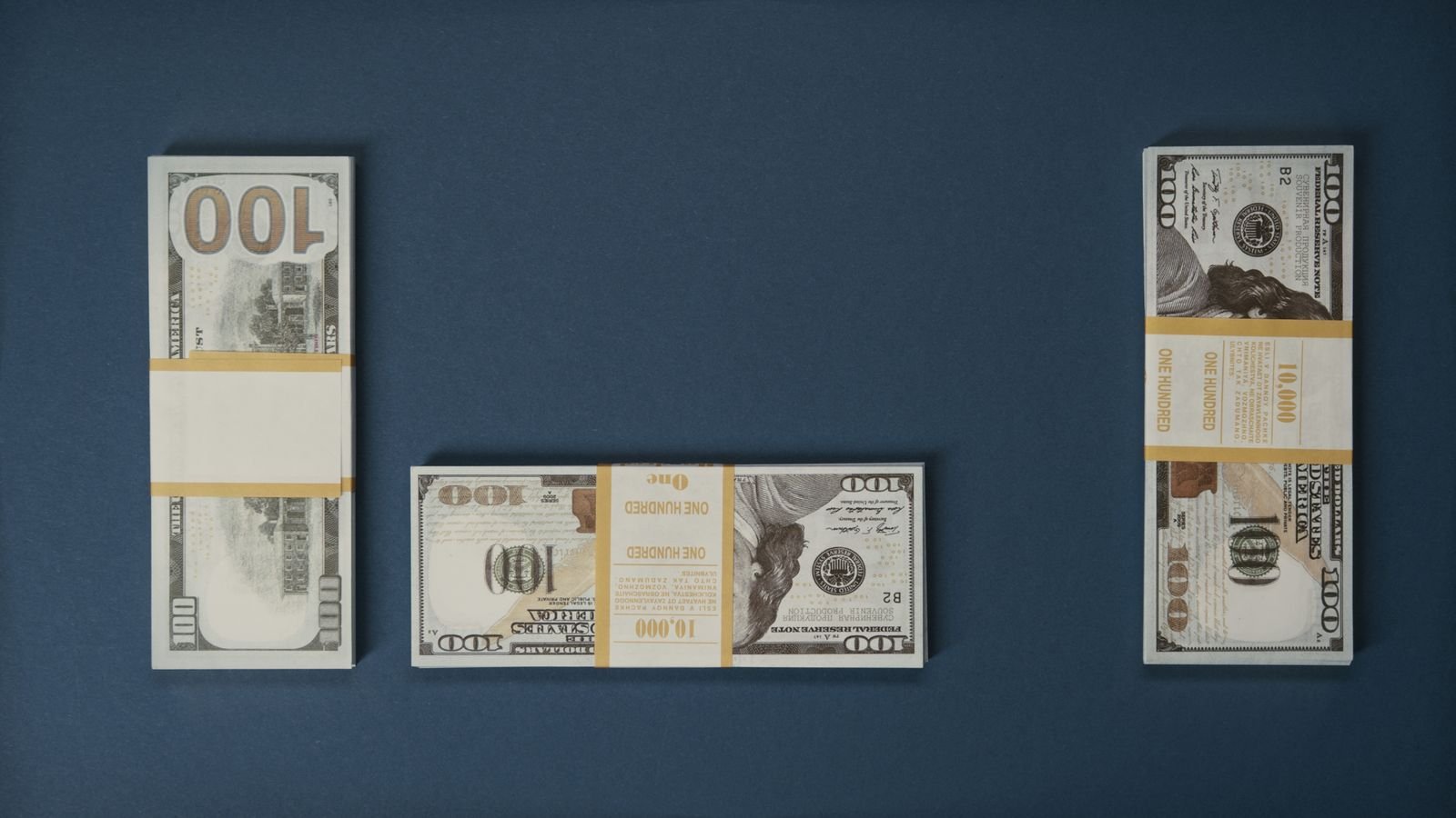Billetes de cien dólares sobre una superficie azul