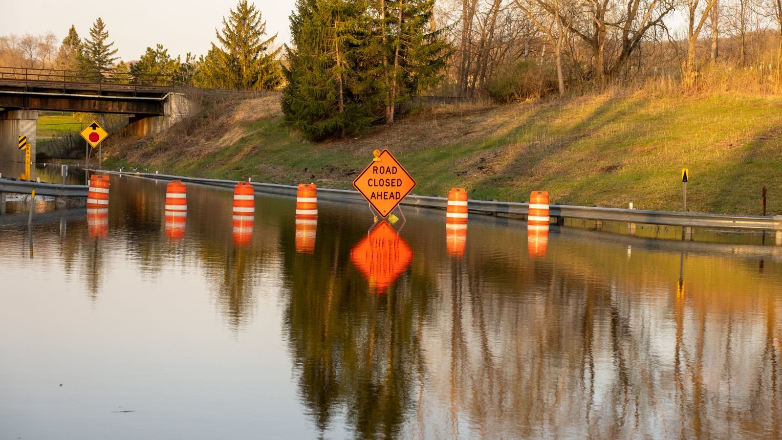 Carretera inundada con una señal de vía cerrada tras fuertes lluvias