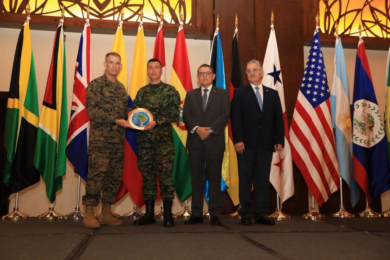 Entrega de reconocimiento durante la clausura de Panamax 2026 ante banderas de los países participantes
