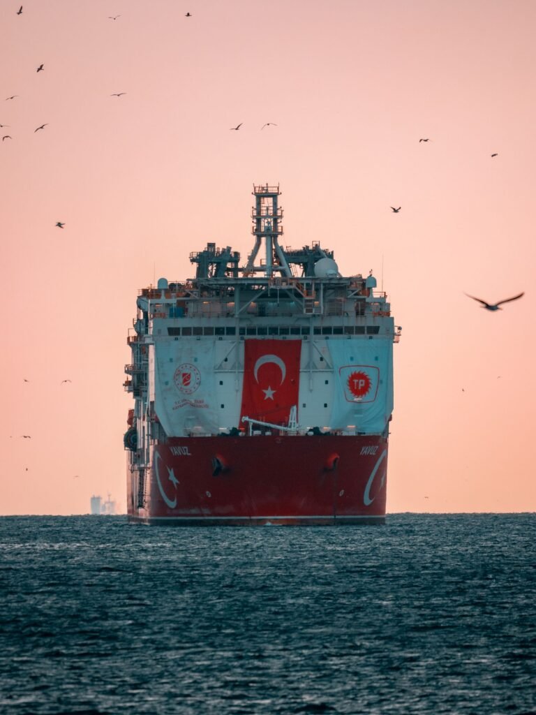 Tanquero con una bandera pintada en el casco navegando al atardecer